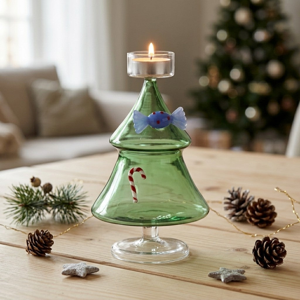 sfeerfoto met brandend waxinelichtje:
“Ichendorf Milano groene glazen kerstboom waxinelichthouder met brandend kaarsje op een houten tafel met kerstdecoratie.