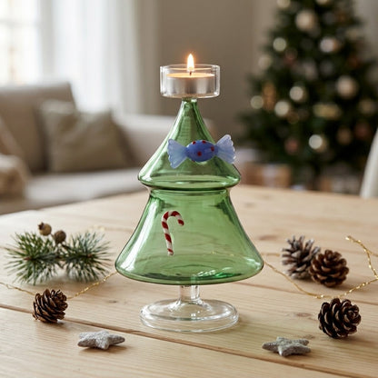 sfeerfoto met brandend waxinelichtje:
“Ichendorf Milano groene glazen kerstboom waxinelichthouder met brandend kaarsje op een houten tafel met kerstdecoratie.
