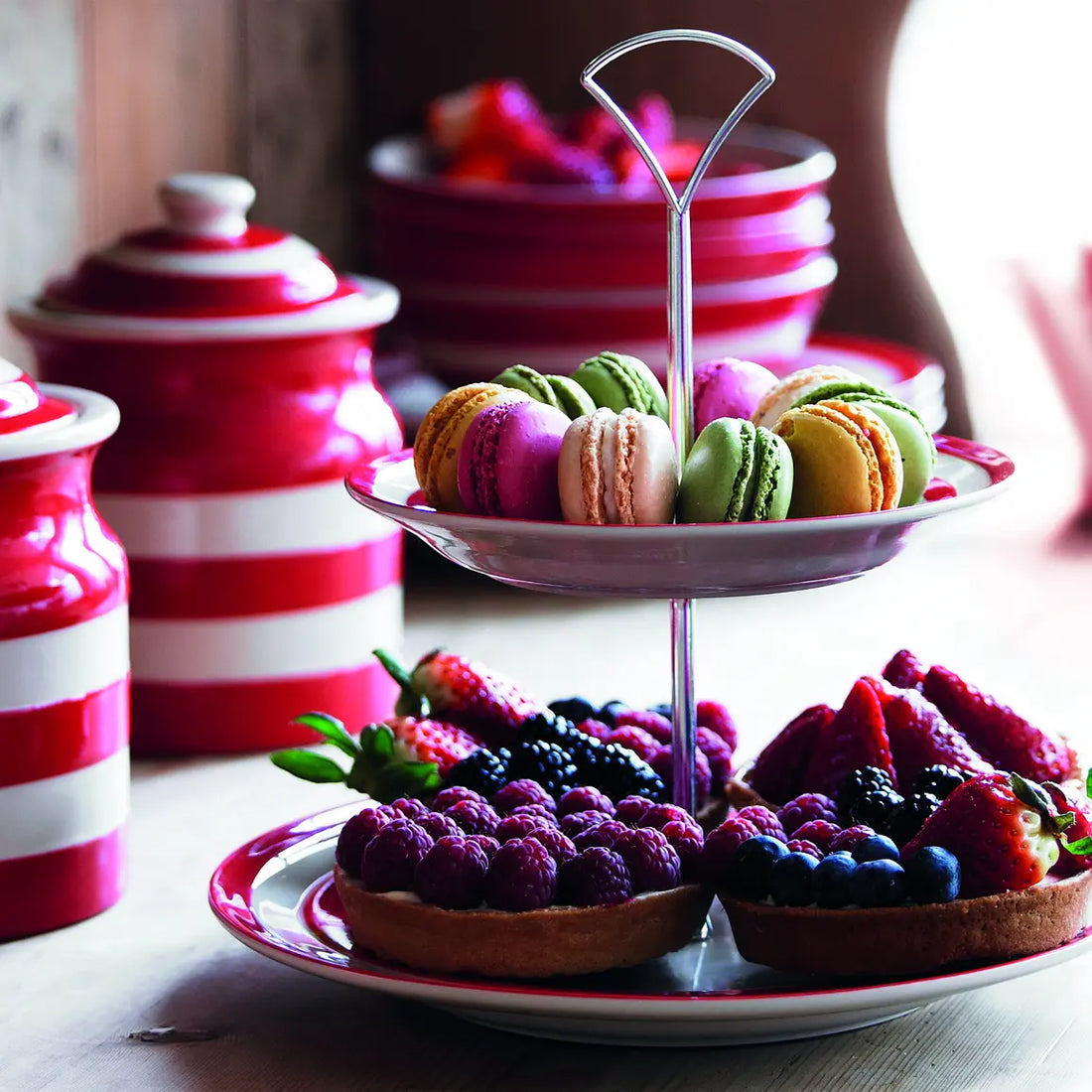 Rood wit gestreepte Cornishware etagère met gebak gebruikt tijdens een tafelsetting